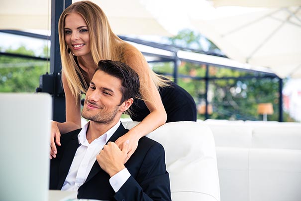 Coworkers sharing a subtle romantic moment while maintaining professionalism in the office